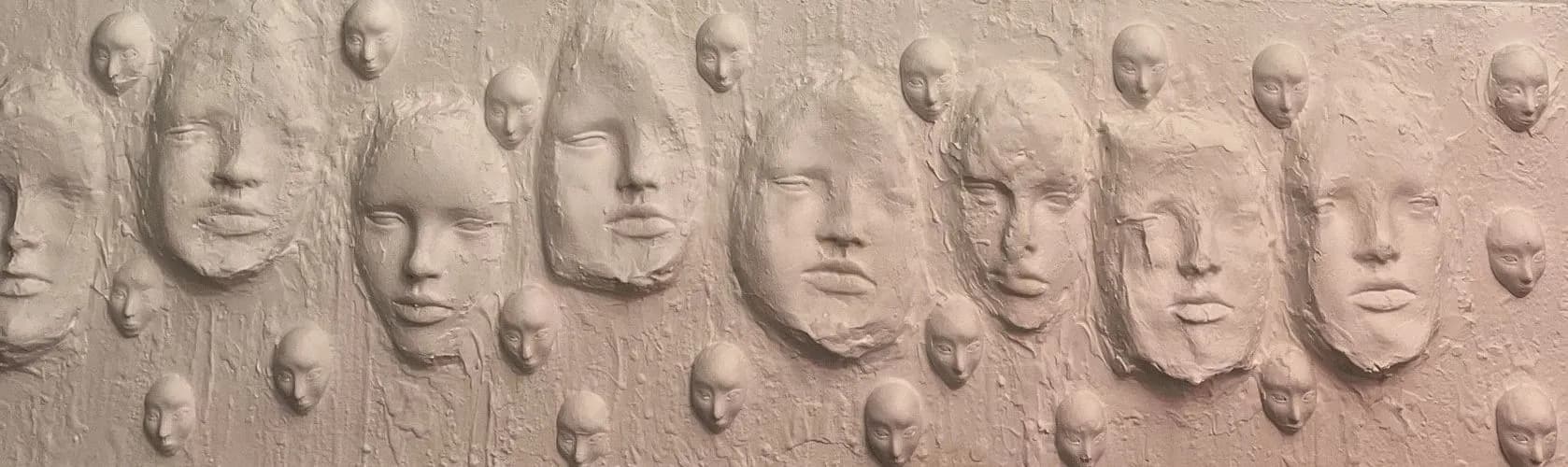 A long pale pink panel from which sleeping faces and rounded heads protrude